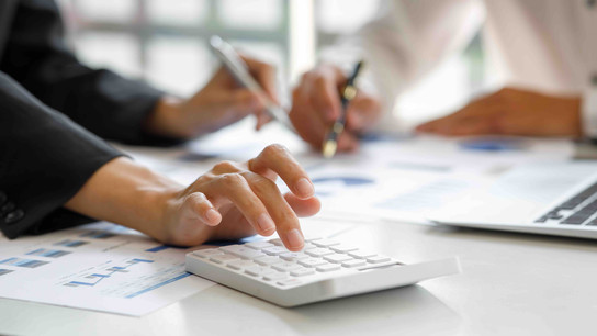 Hands typing and writing on desk