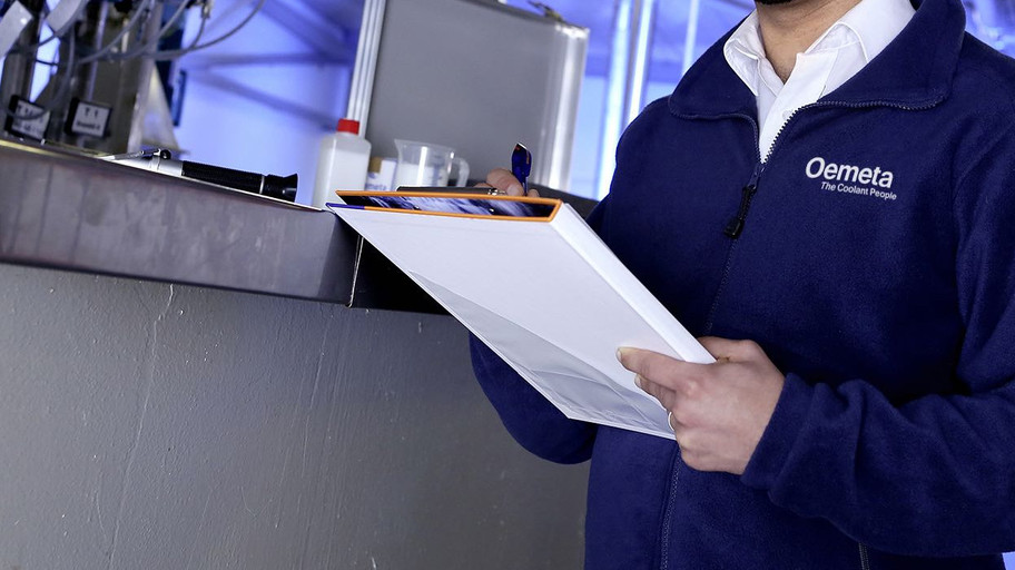 Man with a blue jacket and a checklist in his hands in a production hall