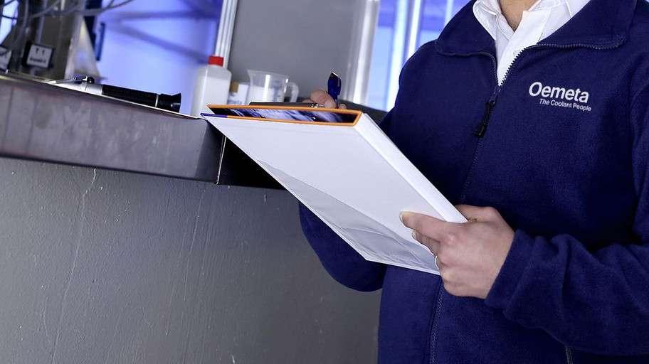 Man with a blue jacket and a checklist in his hands in a production hall