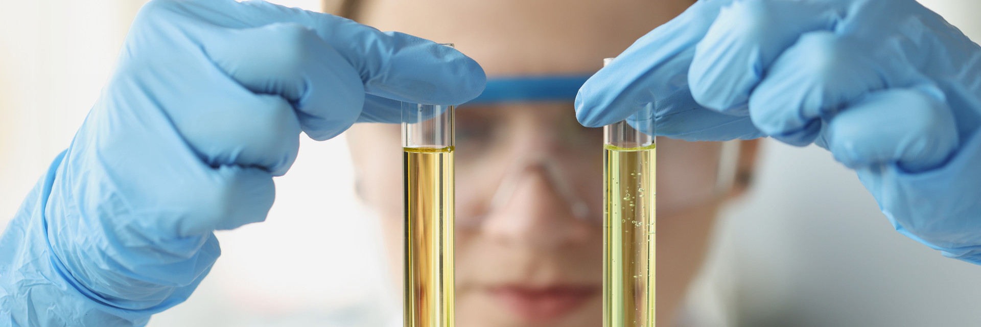 Woman holds two pipettes in her fingers
