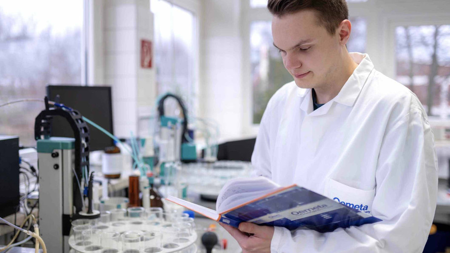 [Translate to United Kingdom (UK):] Chemist in the Oemeta lab leafs through a folder