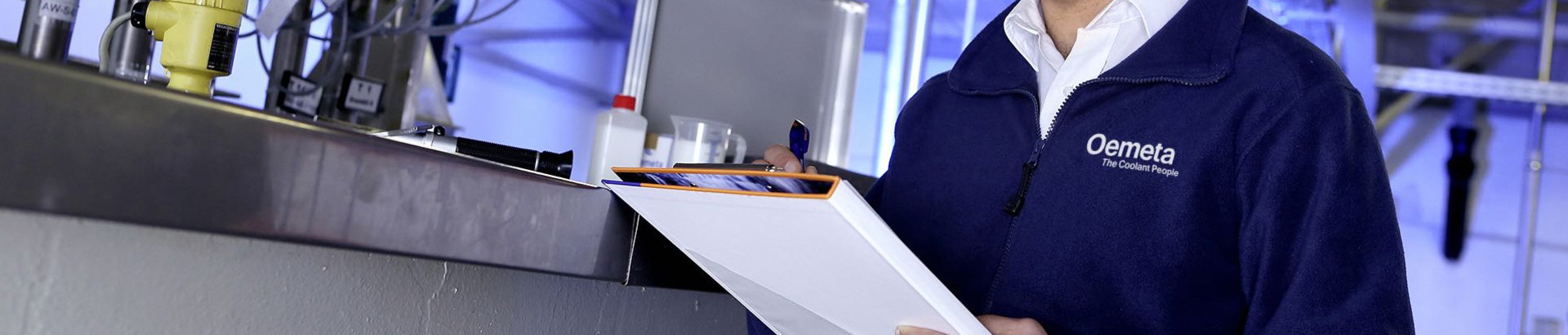 Man with a blue jacket and a checklist in his hands in a production hall