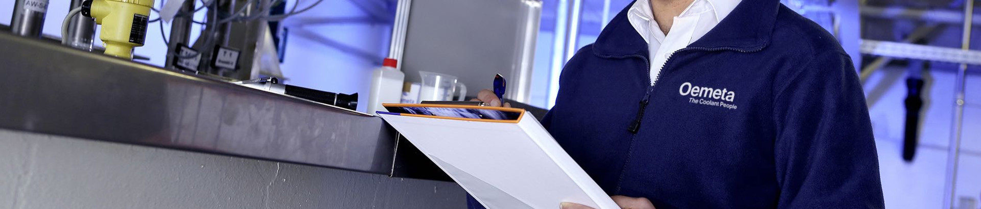 Man with a blue jacket and a checklist in his hands in a production hall