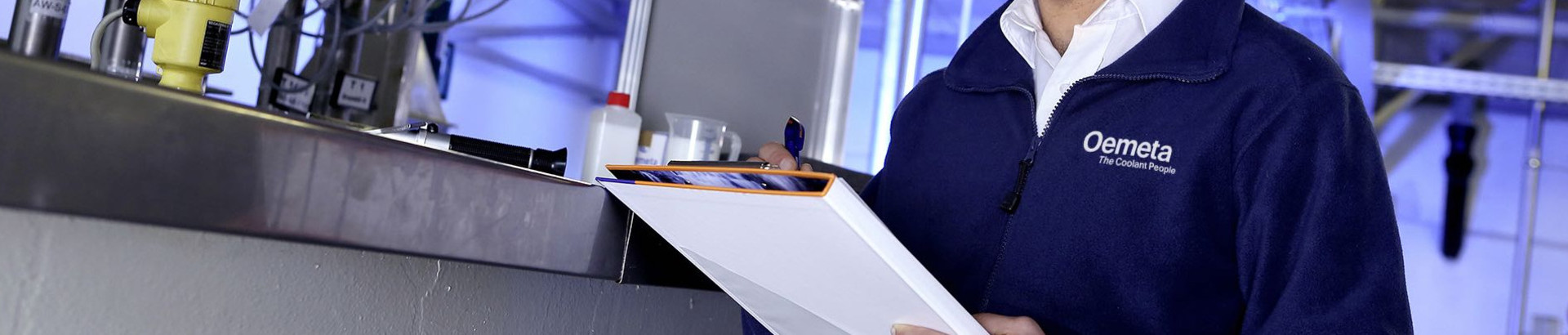 Man with a blue jacket and a checklist in his hands in a production hall