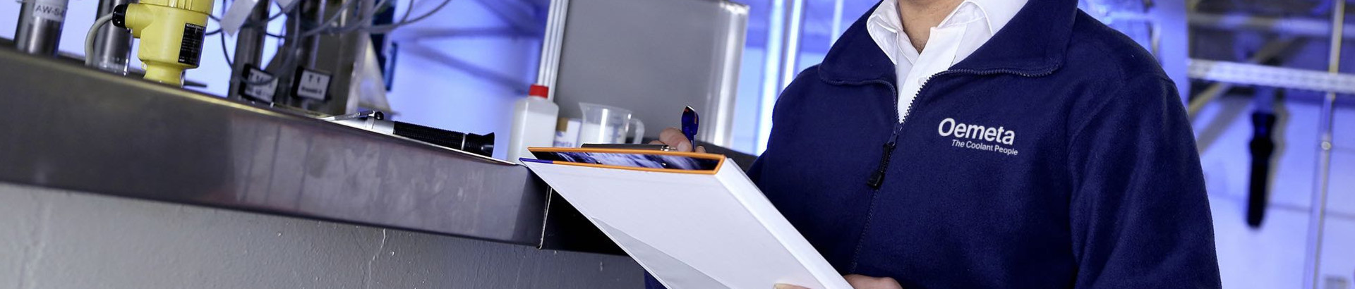 Man with a blue jacket and a checklist in his hands in a production hall