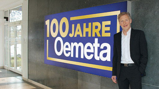 Thomas Vester stands in front of 100 year Oemeta jubilee sign