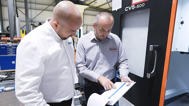 Oemeta and CWM employees in front of the machine